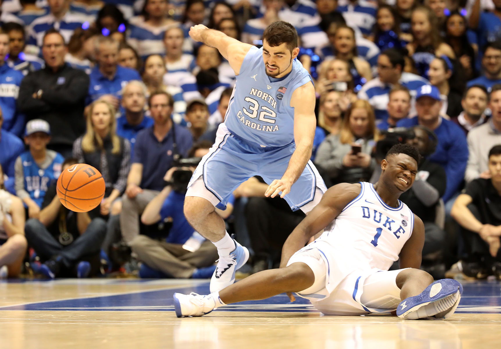 Duke's Zion Williamson (1) reacts after falling as his shoe breaks against North Carolina's Luke Maye (32) at Cameron Indoor Stadium in Durham, N.C., on Wednesday, Feb. 20, 2019. **FOR USE WITH THIS STORY ONLY**